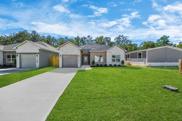 a front view of a house with a garden and yard