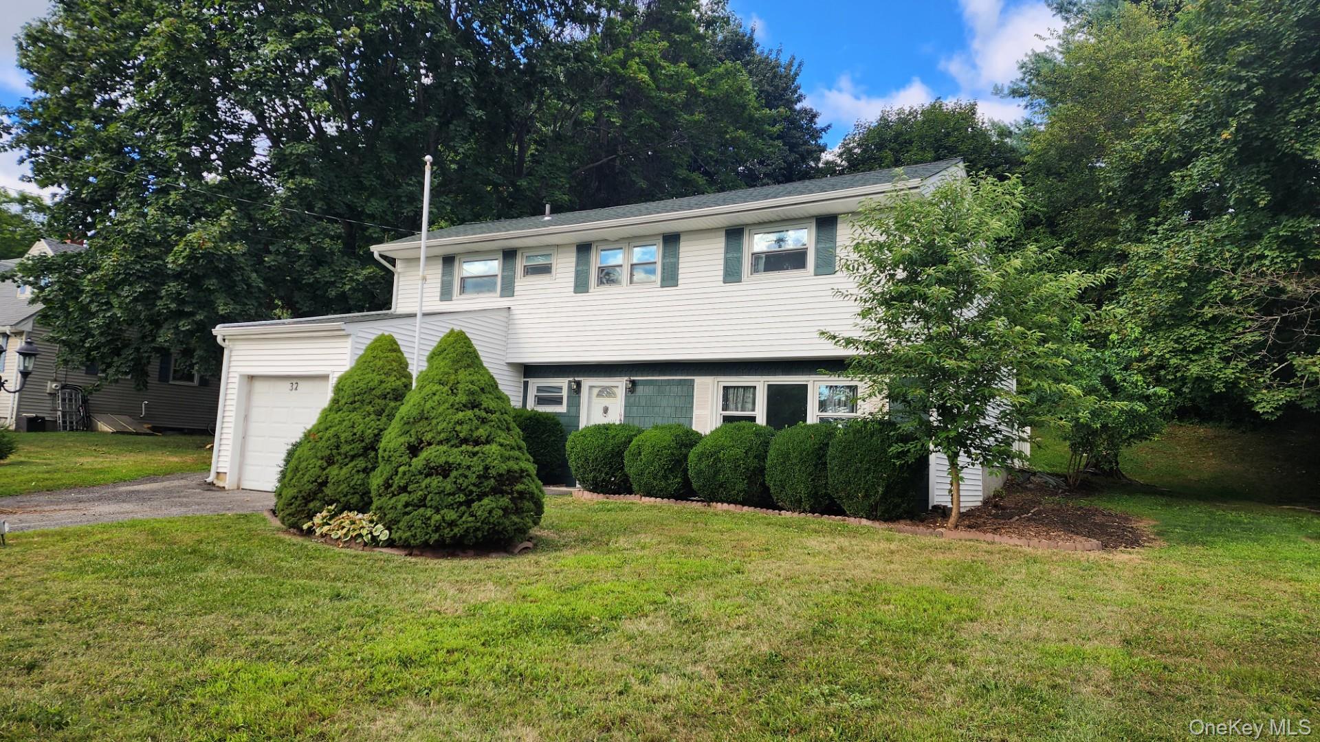 32 Bloomer Road Brewster, NY 10509 - Photo 1 of 18 View of front facade featuring a garage, driveway, and a front lawn