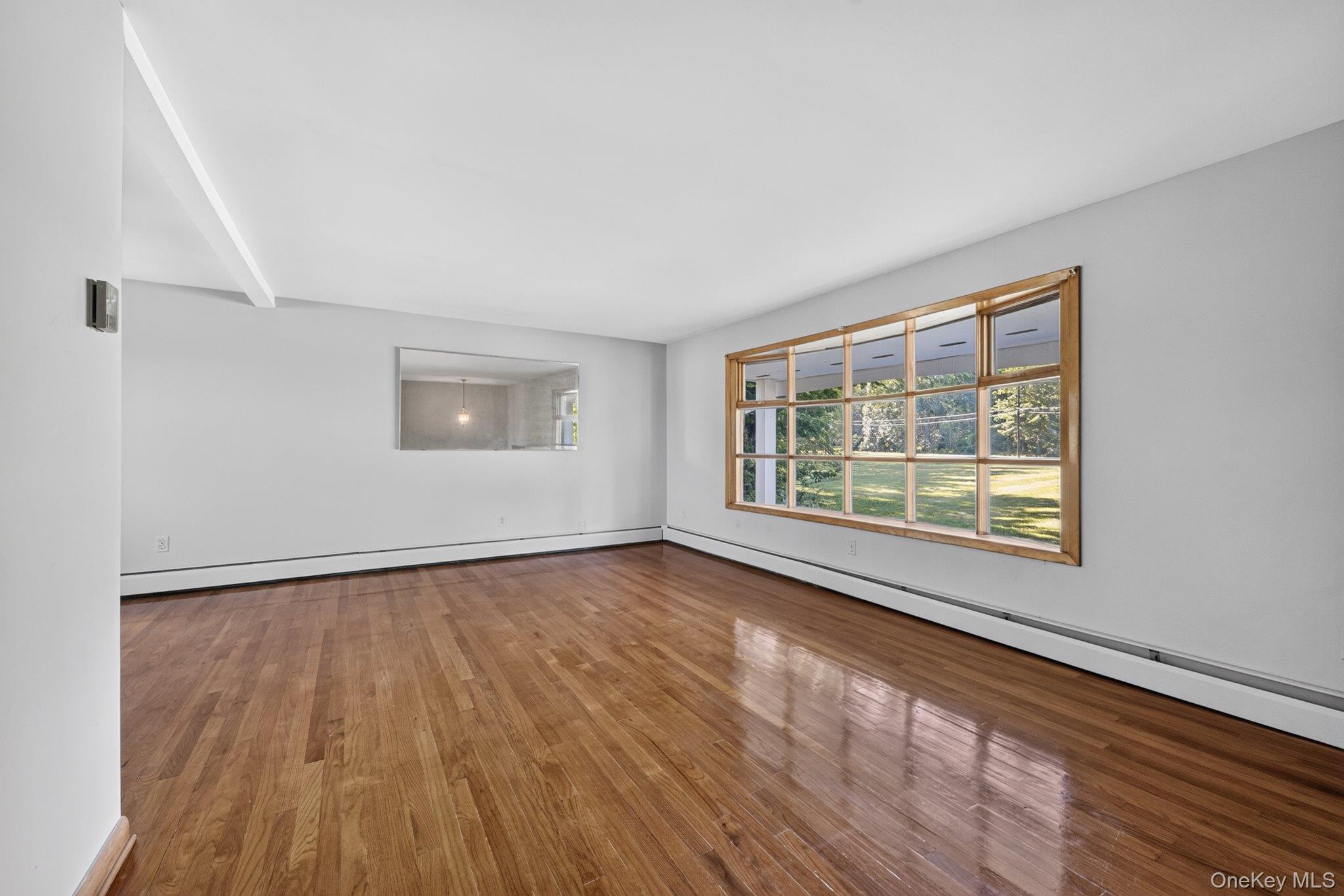 315 Pine Bush Road Stone Ridge, NY 12484 - Photo 12 of 32 a view of an empty room with wooden floor and a window