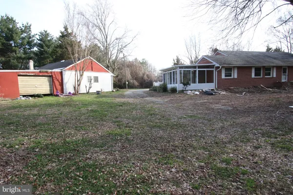a front view of a house with a garden and trees