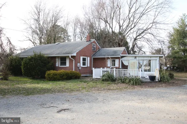 a front view of a house with a garden and trees