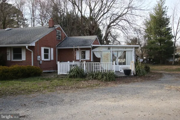 a view of a house with a yard and large trees