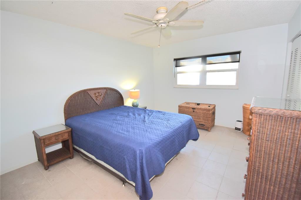 952 Virginia Street, Unit 107 Dunedin, FL 34698 - Photo 5 of 15 a bedroom with a bed and a chandelier