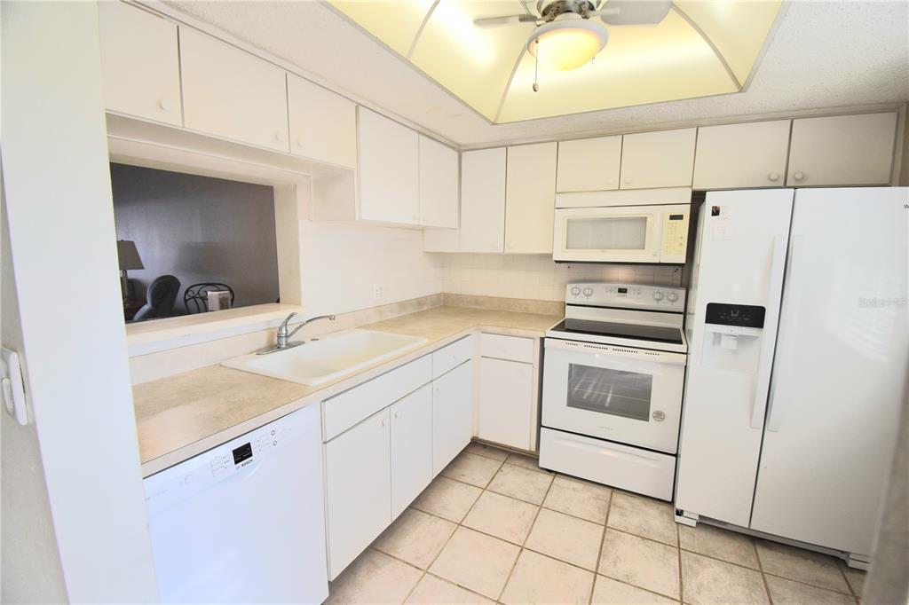 952 Virginia Street, Unit 107 Dunedin, FL 34698 - Photo 7 of 15 a kitchen with a sink cabinets and appliances
