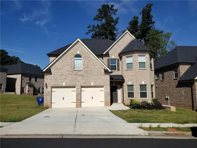 a front view of a house with a yard and garage