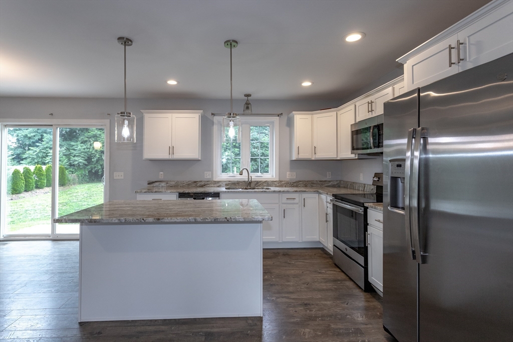50 Edbert Street Chicopee, MA 01020 - Photo 15 of 42 a kitchen with kitchen island granite countertop a stove a sink a center island and stainless steel appliances