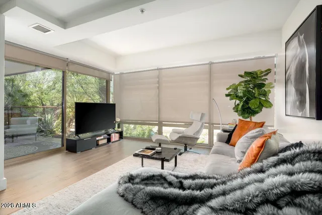 a living room with furniture a flat screen tv and a large window