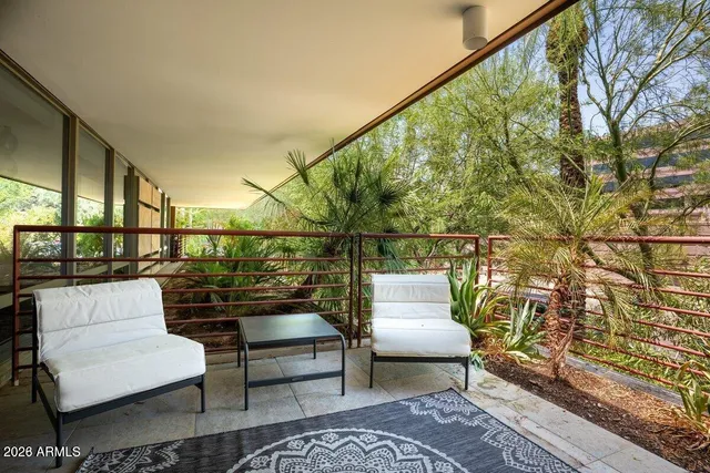 a balcony with wooden floor and outdoor seating