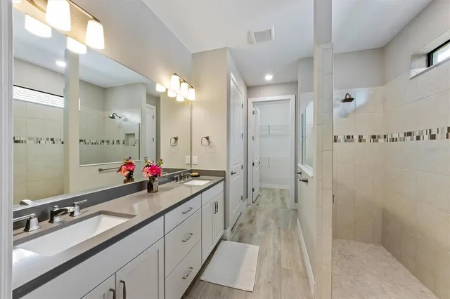 a spacious bathroom with a double vanity sink mirror and shower