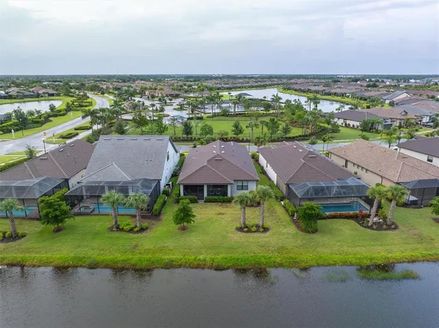 an aerial view of residential houses with outdoor space and lake view
