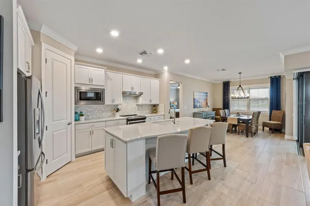 a kitchen with white cabinets and stainless steel appliances