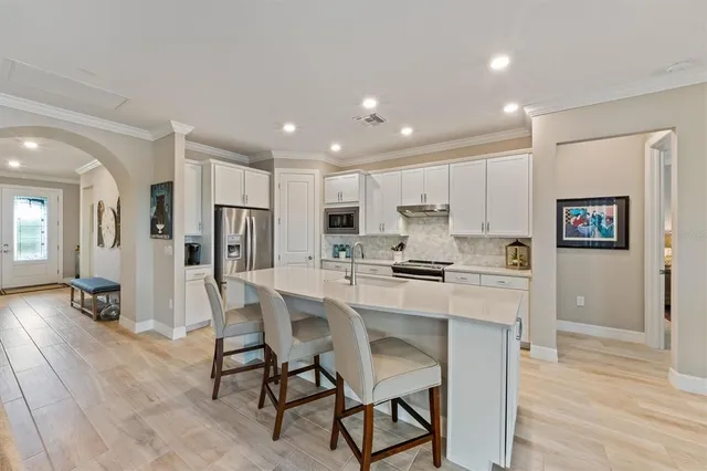 a kitchen with stainless steel appliances kitchen island granite countertop a refrigerator and a stove top oven