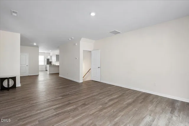 a view of an empty room with wooden floor and a cabinet