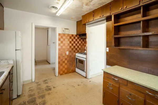 a kitchen with stainless steel appliances granite countertop a refrigerator a stove and a sink with wooden cabinets
