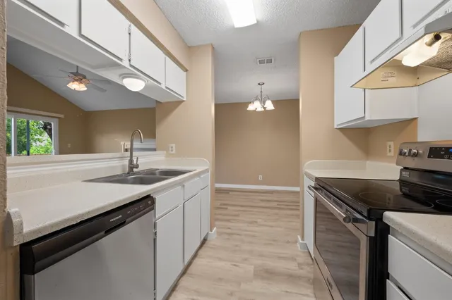a kitchen with a sink cabinets and wooden floor