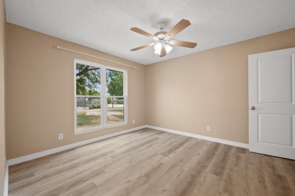 16016 Fitchburg Circle Pflugerville, TX 78660 - Photo 14 of 22 a view of an empty room with wooden floor and a window