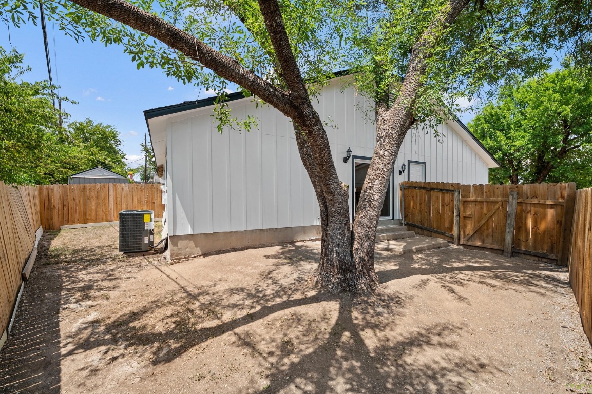 16016 Fitchburg Circle Pflugerville, TX 78660 - Photo 22 of 22 a view of a backyard with wooden fence and a large tree