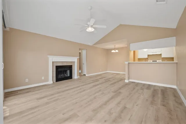 a view of a livingroom with wooden floor and a fireplace