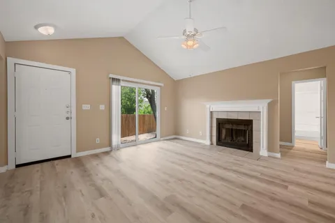 an empty room with windows fireplace and sink