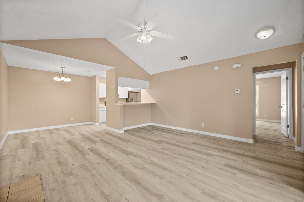 16016 Fitchburg Circle Pflugerville, TX 78660 - Photo 5 of 22 a view of an empty room with wooden floor and a ceiling fan
