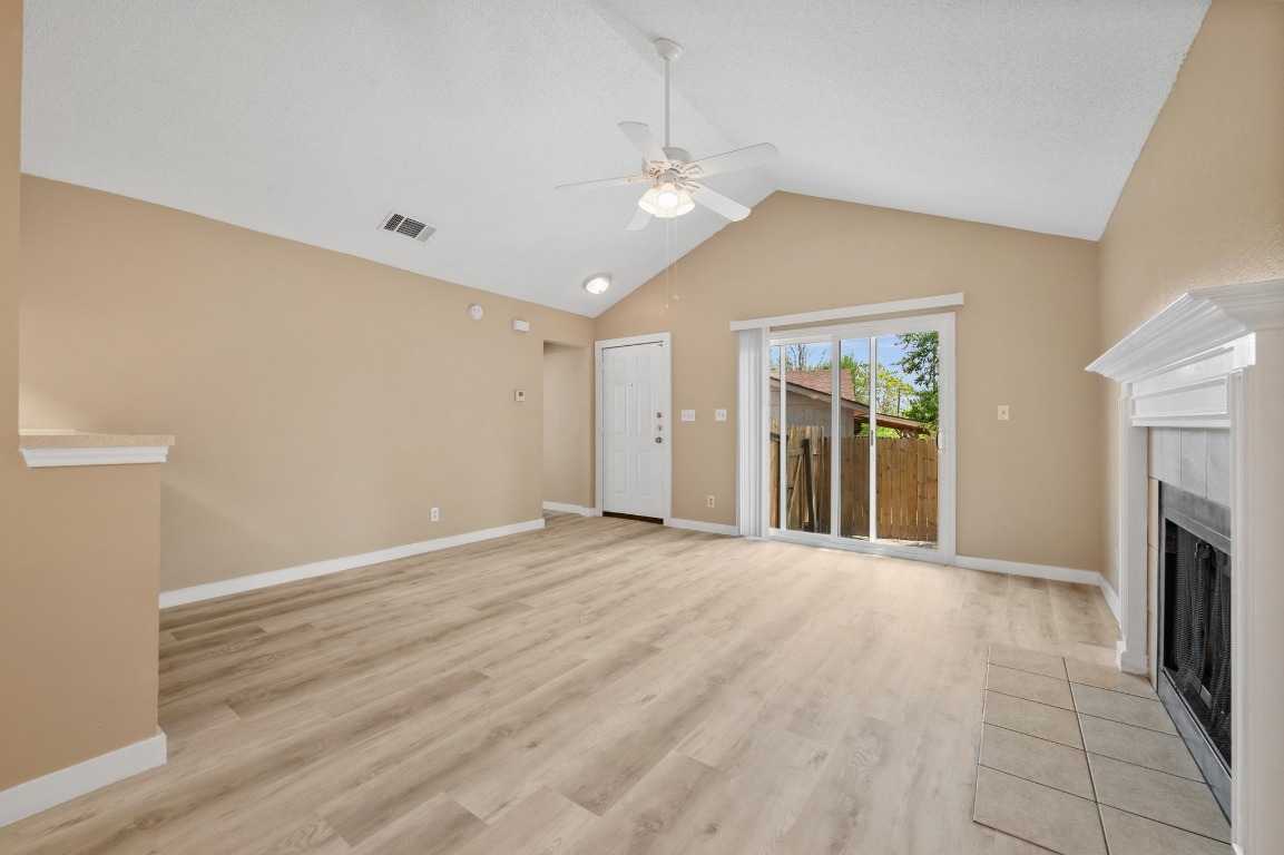 16016 Fitchburg Circle Pflugerville, TX 78660 - Photo 6 of 22 wooden floor in an empty room with a fireplace