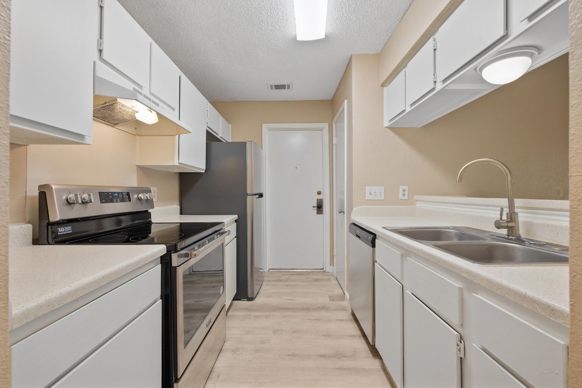 16016 Fitchburg Circle Pflugerville, TX 78660 - Photo 10 of 22 a kitchen with a sink and a stove top oven