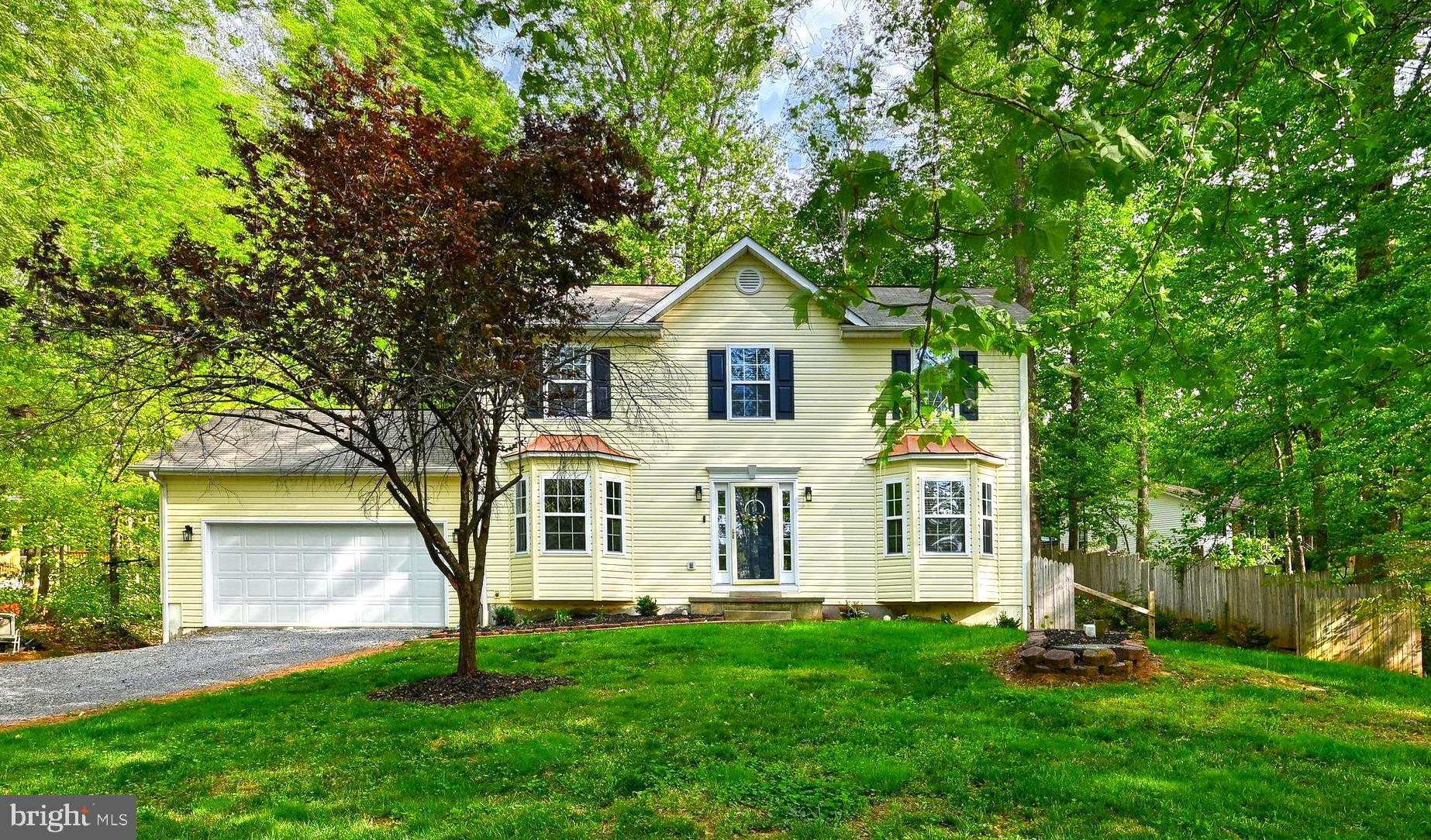a front view of a house with a yard and trees