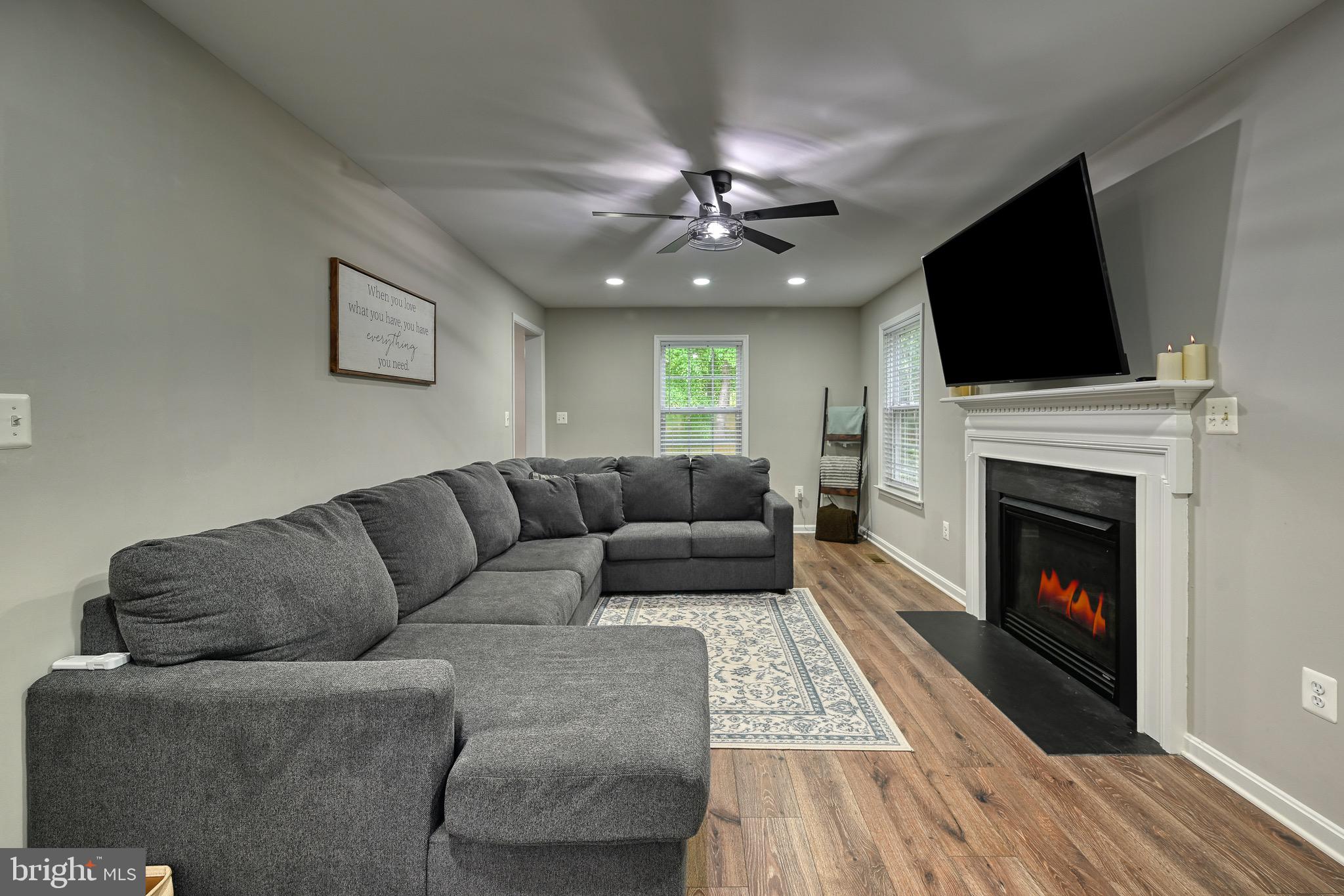 3605 Burton Road Bumpass, VA 23024 - Photo 11 of 39 a living room with furniture a flat screen tv and a fireplace
