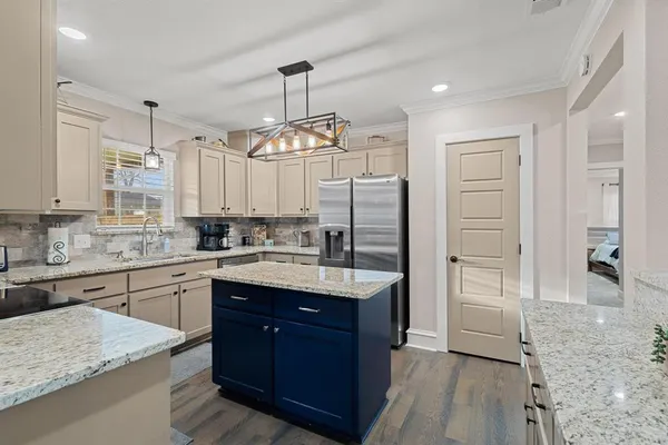 a kitchen with stainless steel appliances granite countertop a sink dishwasher stove and microwave with wooden floor
