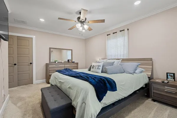 a spacious bedroom with a bed couch and window