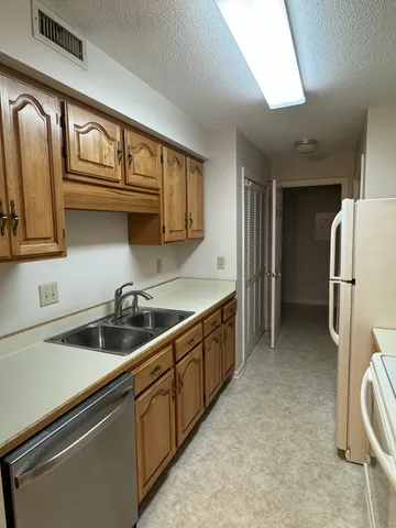 a kitchen with stainless steel appliances a sink a stove and a refrigerator