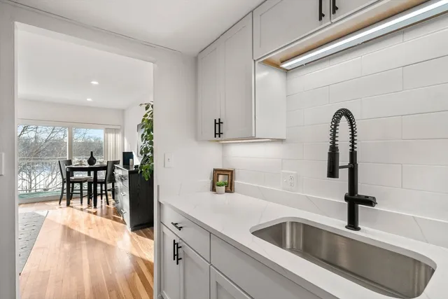 a kitchen with a sink and chairs