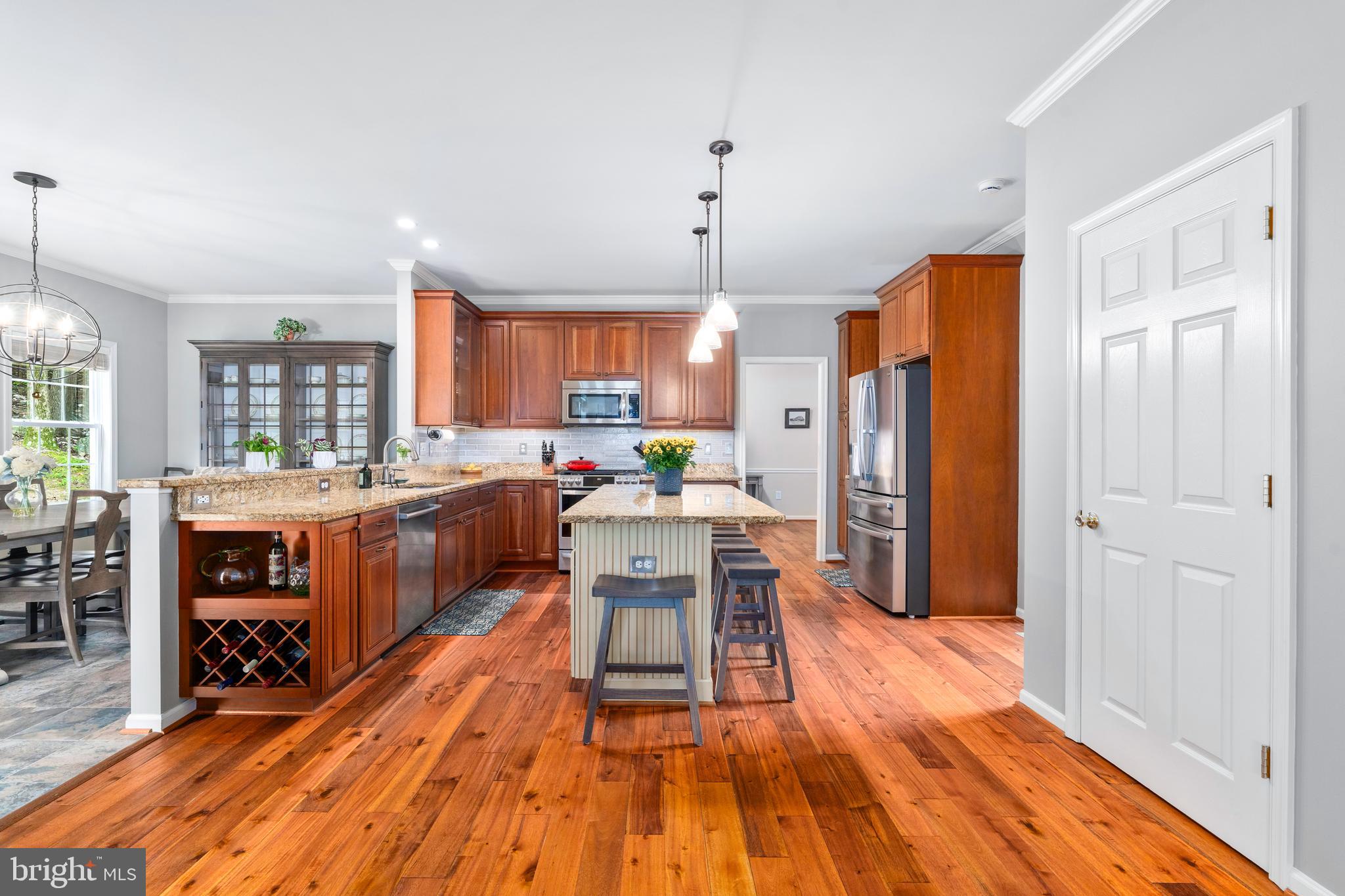 4644 Old Swimming Pool Road Braddock Heights, MD 21714 - Photo 9 of 60 a kitchen with stainless steel appliances a refrigerator a stove a sink dishwasher and a dining table with wooden floor