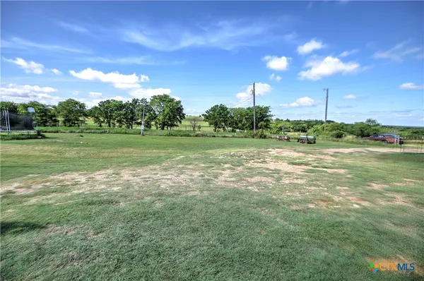 a view of a grassy field with trees