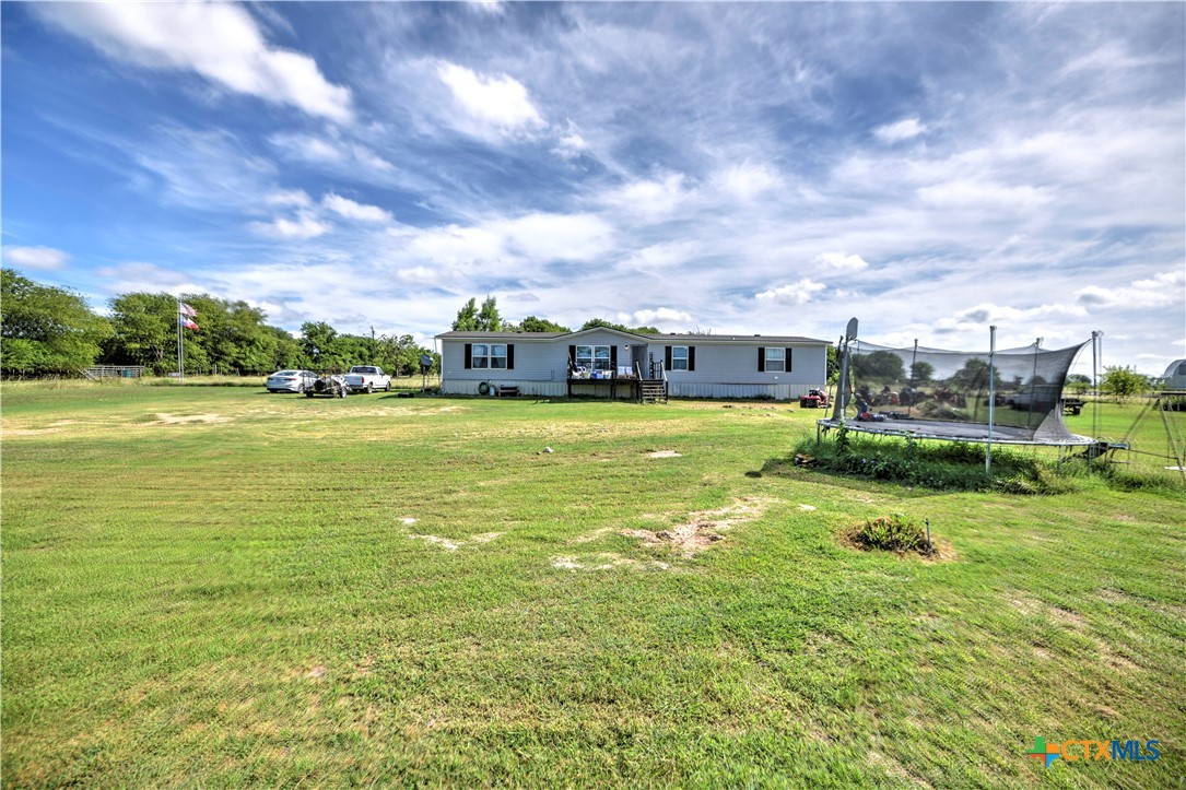 7085 Asa Road Temple, TX 76504 - Photo 7 of 16 a view of a large pool with lawn chairs and a big yard
