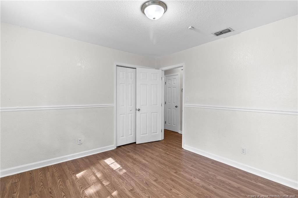 161 Summerhill Road Fayetteville, NC 28303 - Photo 22 of 36 an empty room with wooden floor and windows