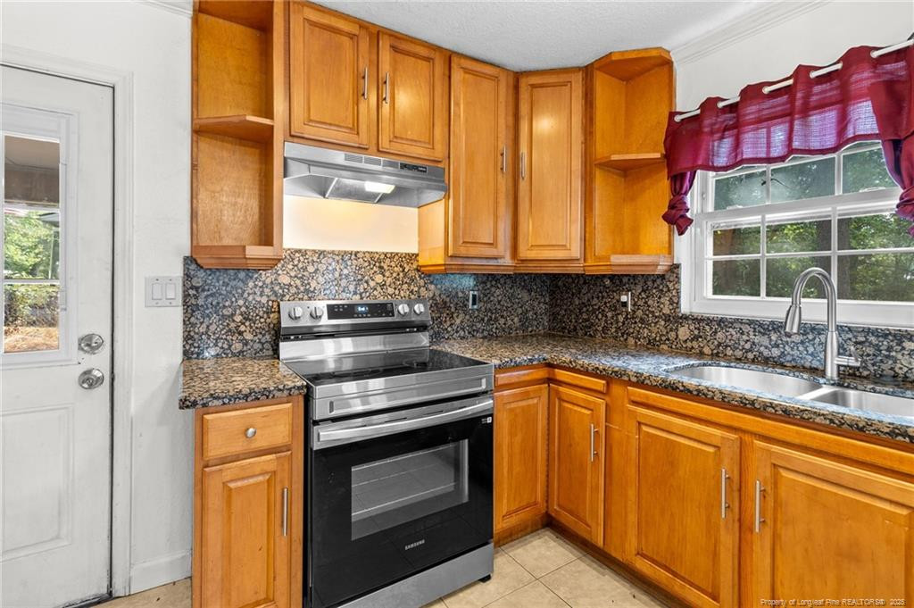 161 Summerhill Road Fayetteville, NC 28303 - Photo 24 of 36 a kitchen with stainless steel appliances granite countertop a stove a sink and a microwave