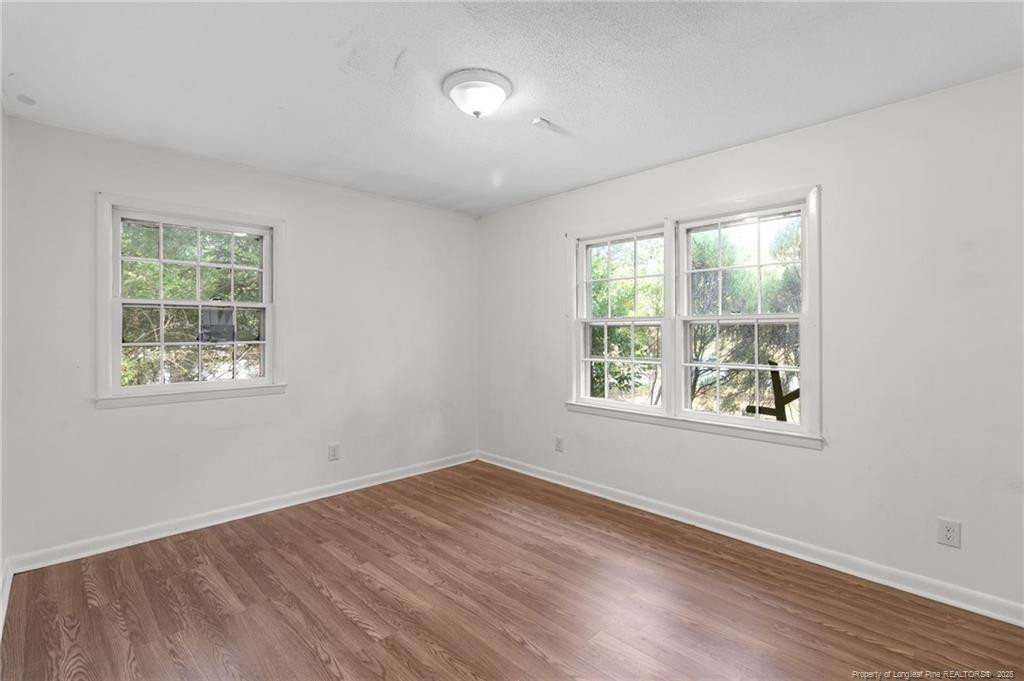161 Summerhill Road Fayetteville, NC 28303 - Photo 7 of 36 an empty room with wooden floor and windows