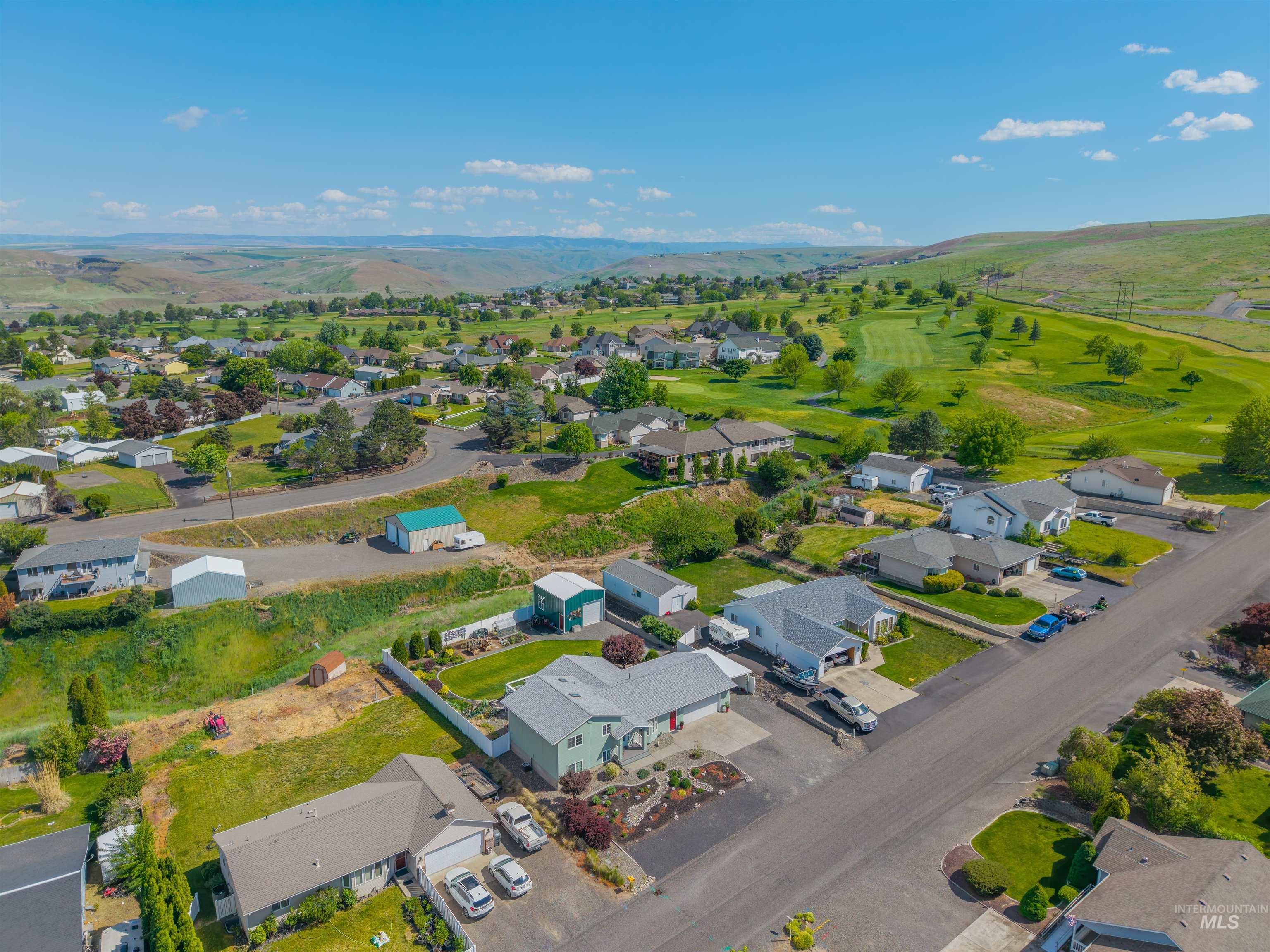 2237 Chukar Lane Clarkston, WA 99403 - Photo 45 of 46 Aerial perspective showcasing a residential area with a golf course and rolling hills in the background