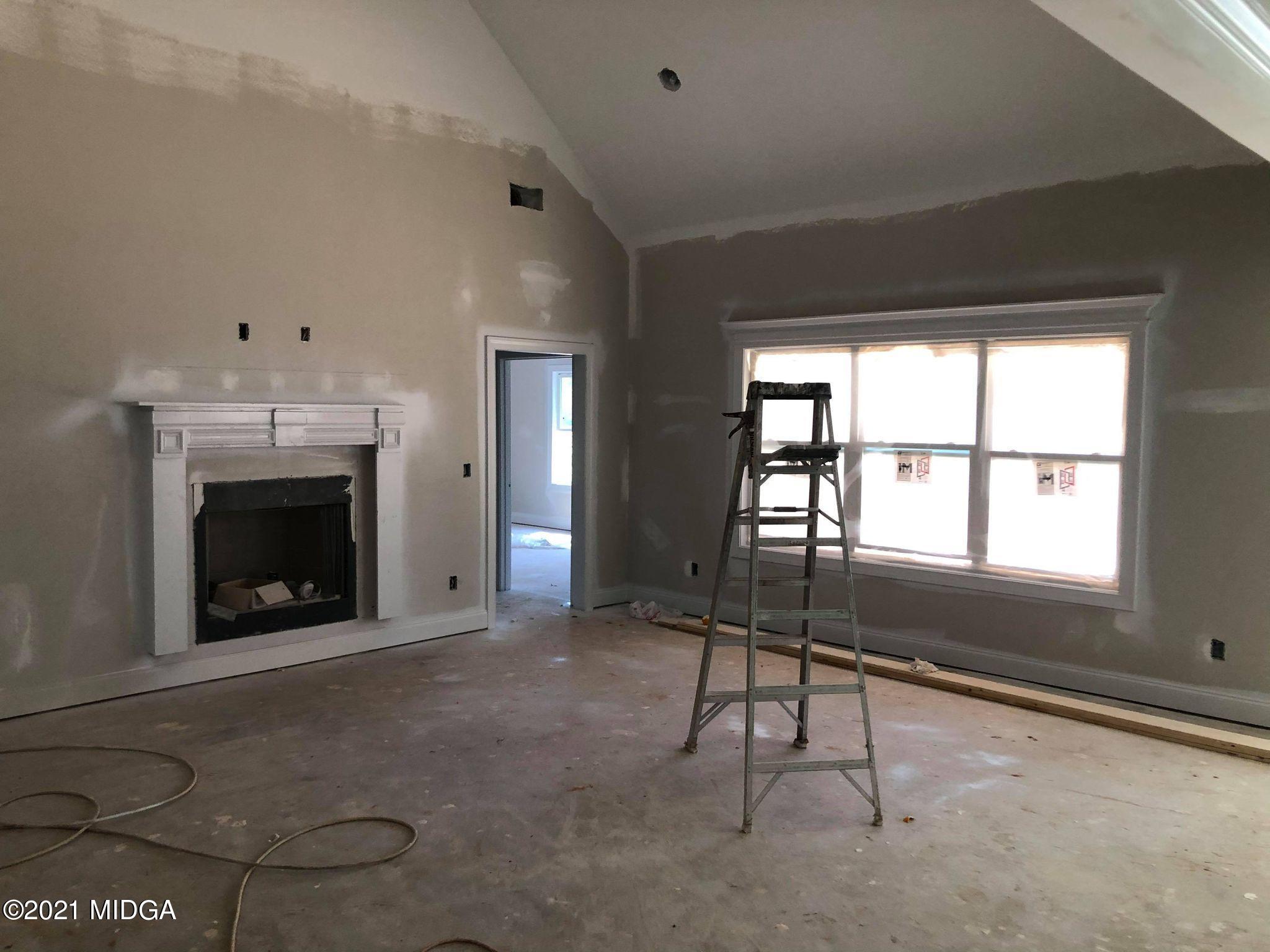 948 Chappell Mill Road Milner, GA 30257 - Photo 2 of 5 a living room with a fireplace and a floor to ceiling window
