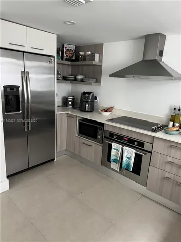a kitchen with stainless steel appliances granite countertop a refrigerator and a stove