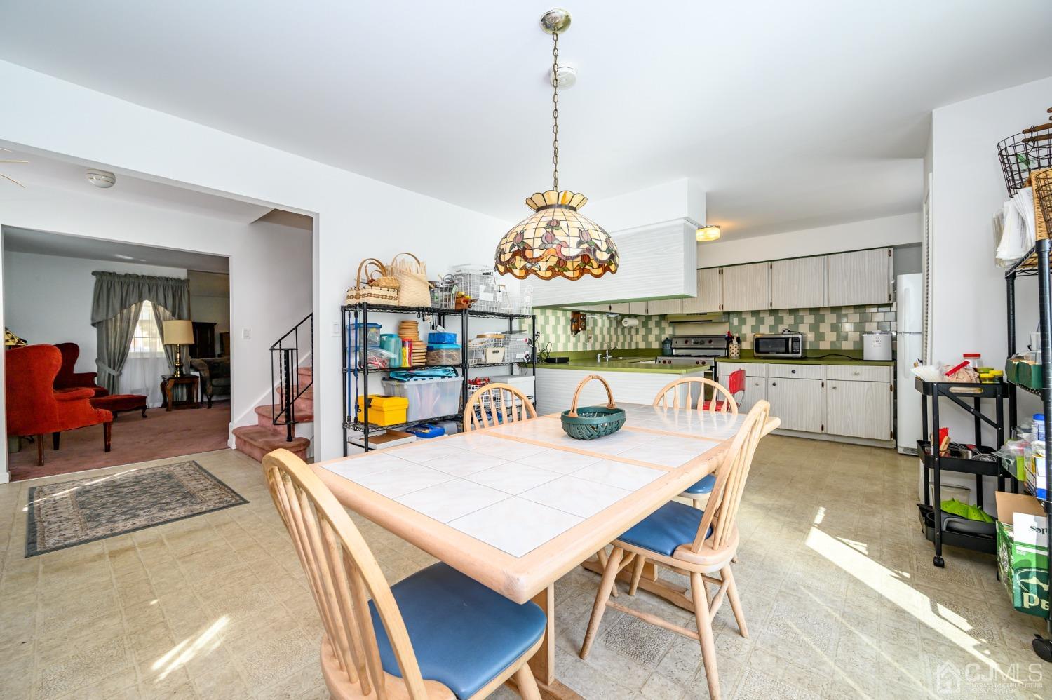 334 High Street Perth Amboy, NJ 08861 - Photo 8 of 33 a dining room with wooden floor a chandelier a wooden table and chairs