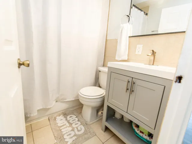 a view of a bedroom with a window and refrigerator