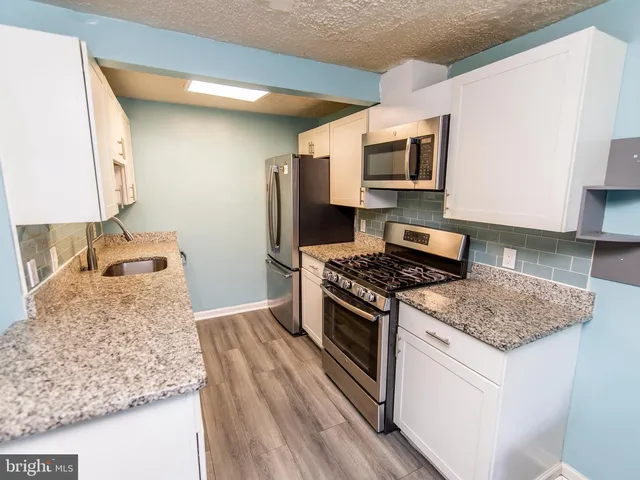 a kitchen with stainless steel appliances granite countertop a stove and a microwave