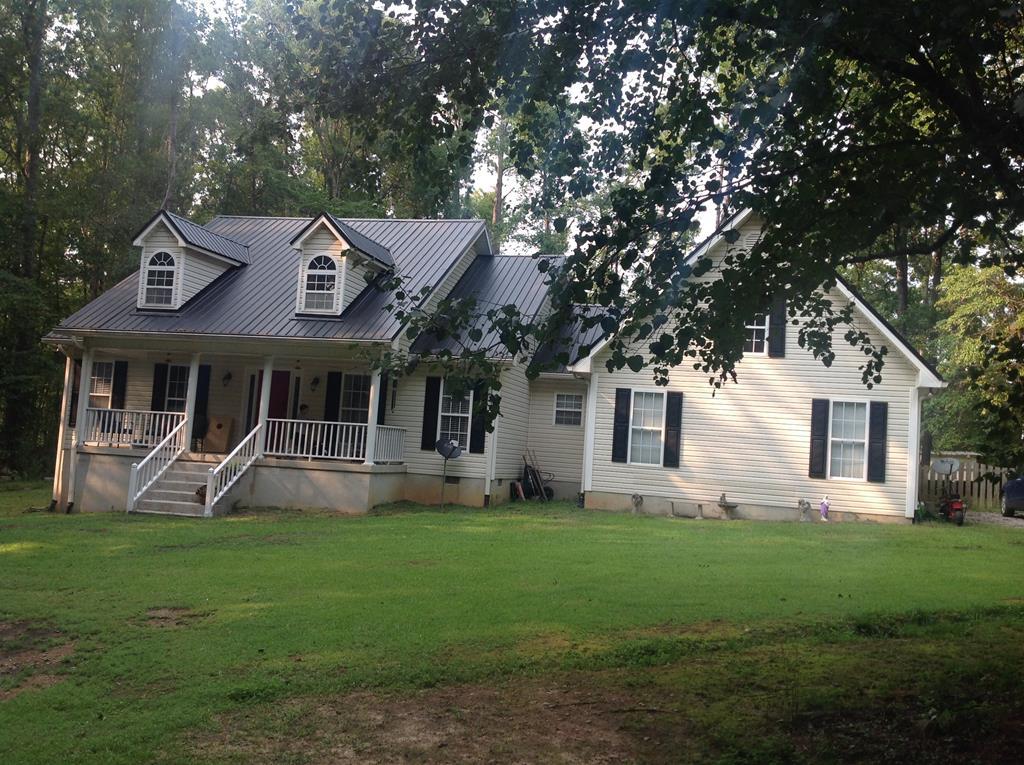 a front view of a house with a garden and trees