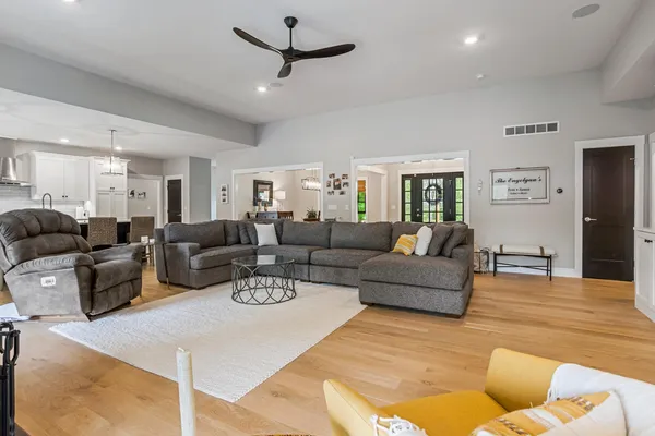 a kitchen with stainless steel appliances granite countertop a stove top oven a refrigerator a sink and a dining table with wooden floor