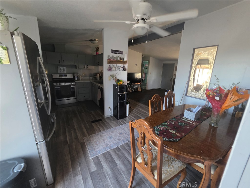 10623 Desert View Road Pinon Hills, CA 92372 - Photo 32 of 76 a kitchen with stainless steel appliances granite countertop a refrigerator stove top oven dining table and chairs