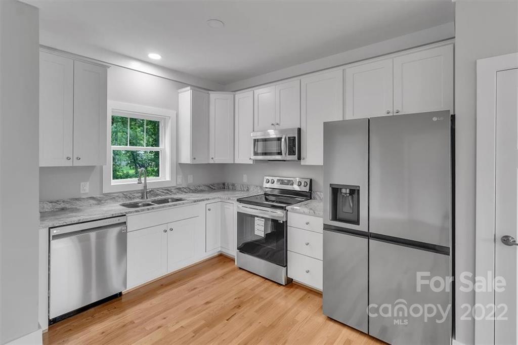 225 Ridge View Drive, Unit 16 Clyde, NC 28721 - Photo 11 of 29 a kitchen with white cabinets stainless steel appliances and window
