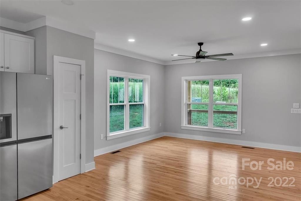 225 Ridge View Drive, Unit 16 Clyde, NC 28721 - Photo 12 of 29 a view of an empty room with wooden floor and a window