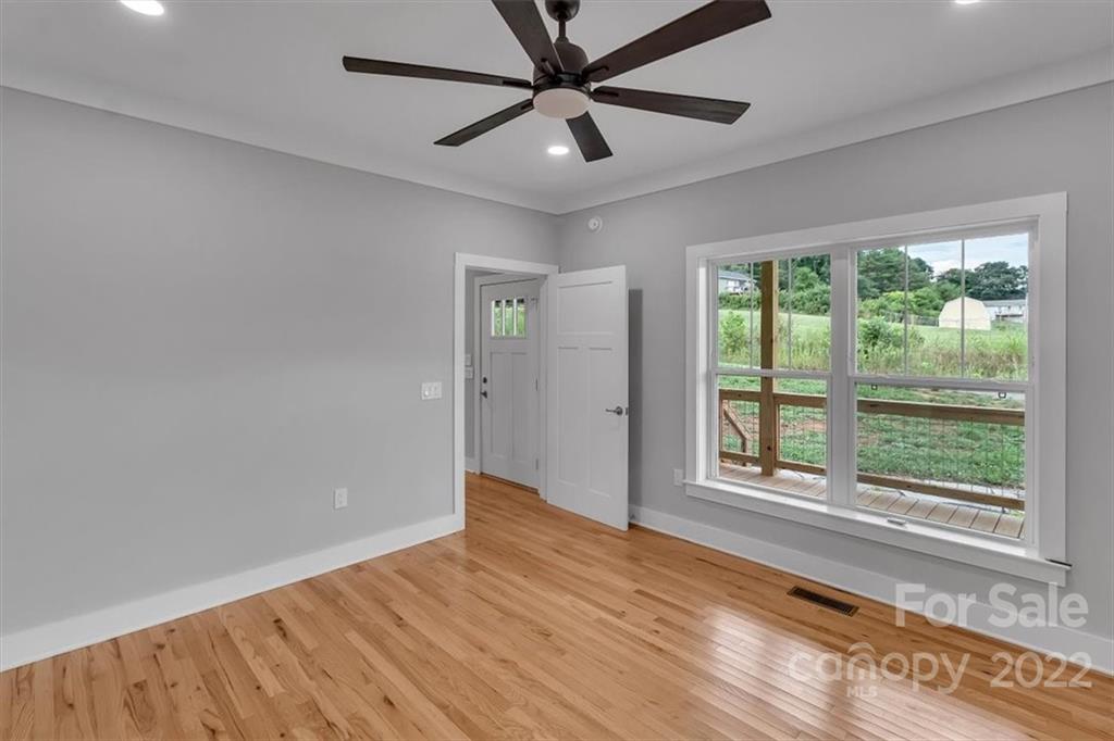 225 Ridge View Drive, Unit 16 Clyde, NC 28721 - Photo 14 of 29 a view of an empty room with a window and wooden floor